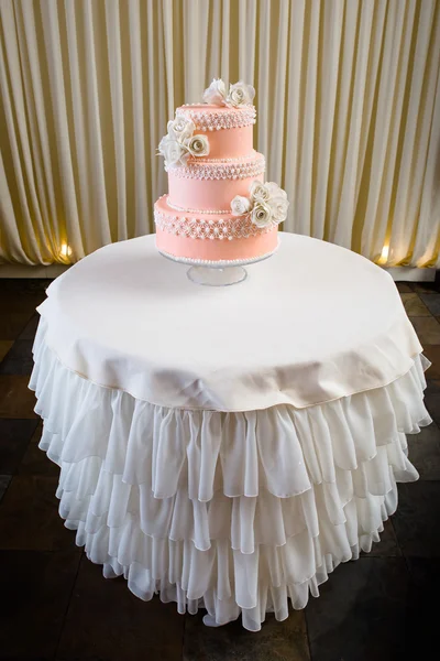 Roze en witte bruidstaart op witte tafel — Stockfoto