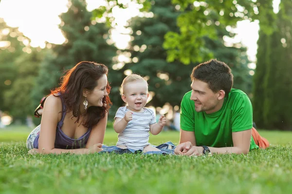 Jóvenes padres atractivos y retrato infantil al aire libre — Foto de Stock