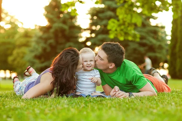 Jóvenes padres atractivos y retrato infantil al aire libre — Foto de Stock