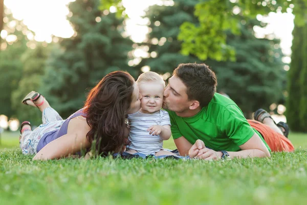 Jóvenes padres atractivos y retrato infantil al aire libre — Foto de Stock