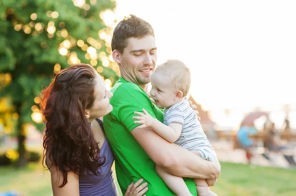 Jóvenes padres atractivos y retrato infantil al aire libre — Foto de Stock