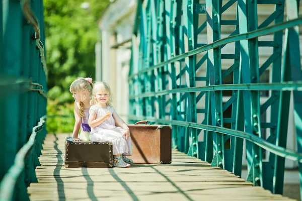 Imagen de aspecto vintage de las niñas pequeñas con el equipaje en el ferrocarril —  Fotos de Stock