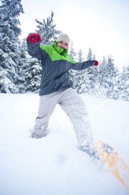 uzun yürüyüşe çıkan kimse kar ormanda yürür