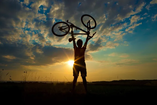 Biker houdt fiets hoog in de lucht — Stockfoto