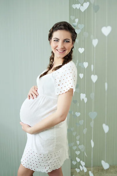 Krásná těhotná žena doma podívat na kameru — Stock fotografie