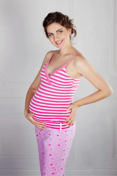 Hermosa hembra embarazada en casa mira a la cámara — Foto de Stock