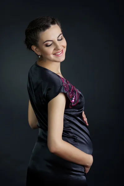 Hermosa hembra embarazada en casa mira a la cámara — Foto de Stock