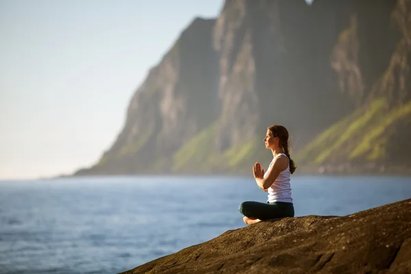 Mujer joven practica yoga entre montañas en Noruega — Foto de Stock