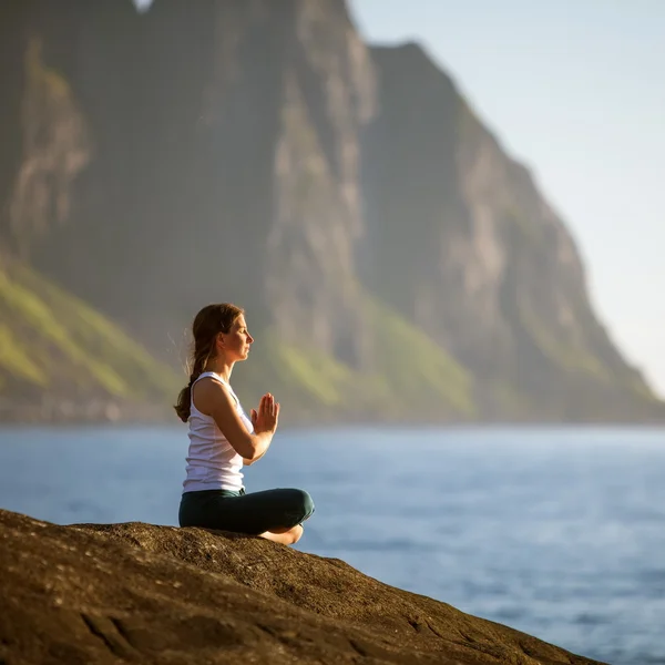 Ung kvinna utövar yoga mellan bergen i Norge — Stockfoto