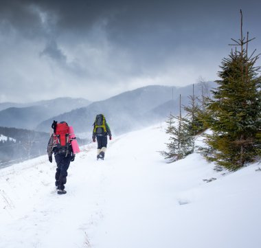 Kış dağlarında yürüyüş yapan