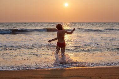 Kadın geri kalan deniz sahilinde alır.