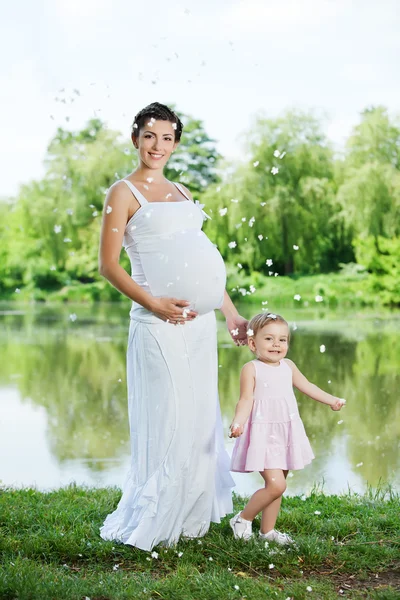 妊娠中の母親と彼女の娘は、屋外の楽しい時を過す — ストック写真