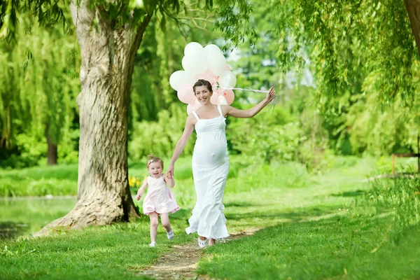 Mãe grávida e sua filha se divertir ao ar livre — Fotografia de Stock