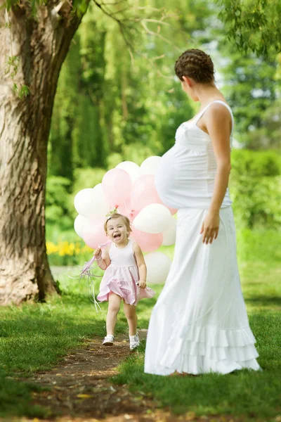 Mère enceinte et sa fille s'amusent en plein air — Photo