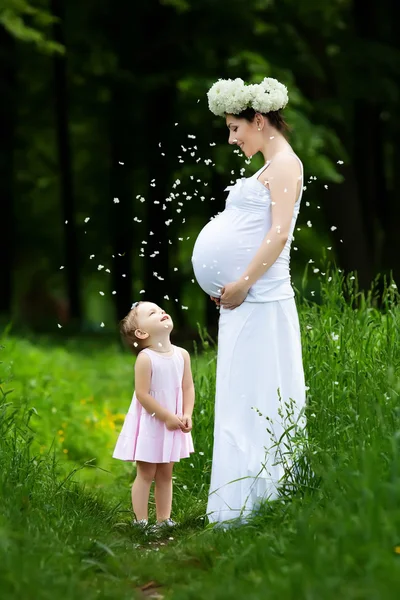 Mãe grávida e sua filha se divertir ao ar livre — Fotografia de Stock