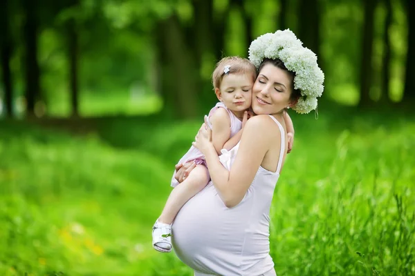 Pregnant mother and her daughter have fun outdoor — Stock Photo, Image