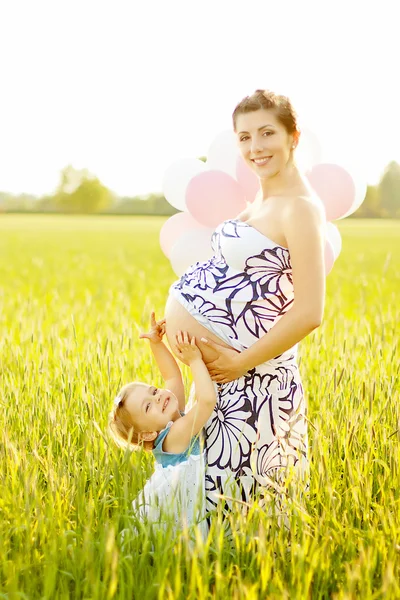 Mãe grávida e sua filha se divertir ao ar livre — Fotografia de Stock