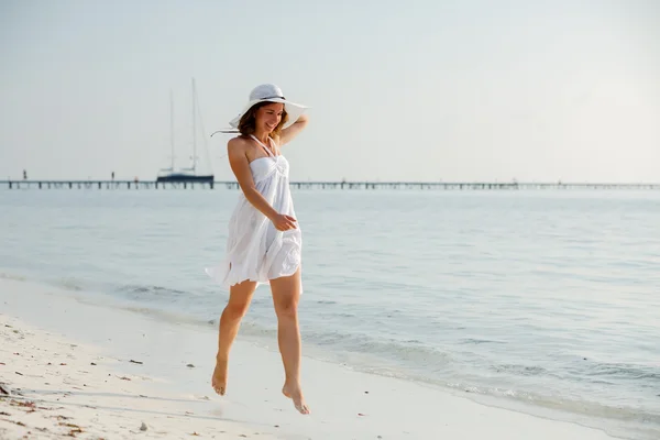 Gelukkig jong vrouw springen op het strand — Stockfoto