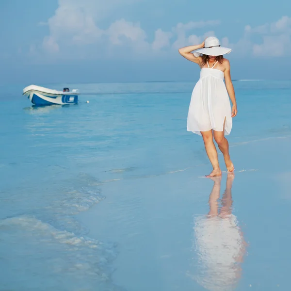 Caucasian woman walks along beautiful seashore — Stock Photo, Image