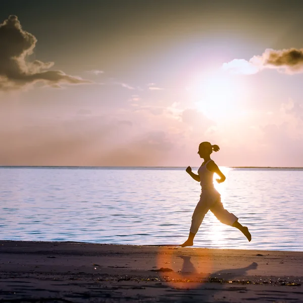 Kaukasisk kvinna jogging på havsstranden — Stockfoto