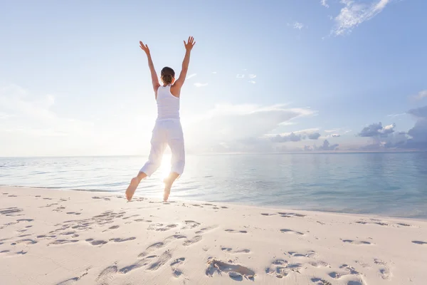 Jovem feliz pulando na praia — Fotografia de Stock
