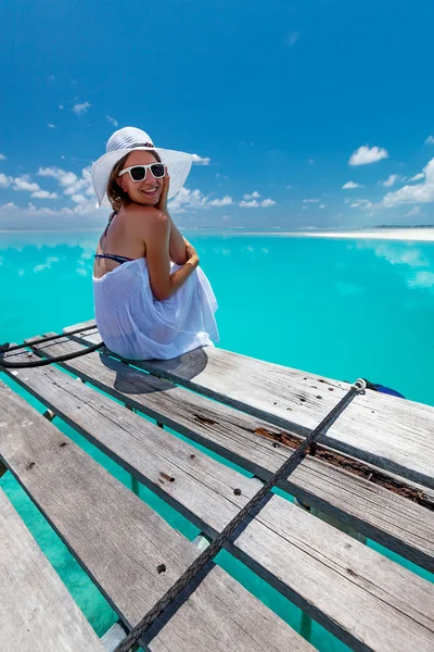 Caucasian woman takes rest at wooden pier to Indian ocean — Stock Photo, Image