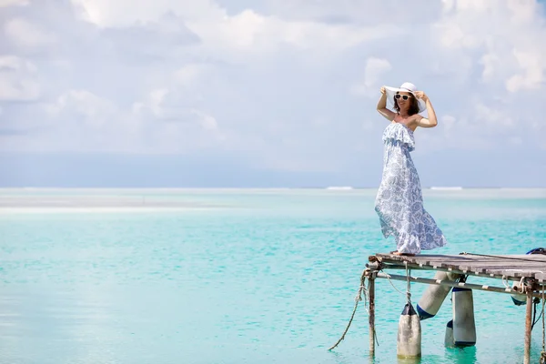 Caucasian woman takes rest at wooden pier to Indian ocean — Stock Photo, Image