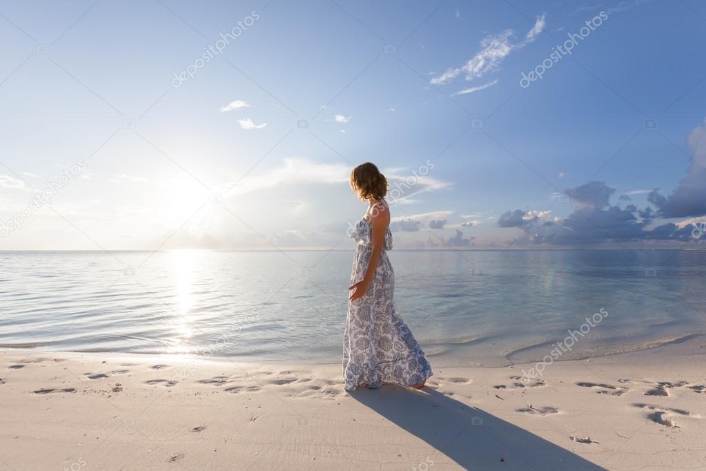 Caucasian woman walks along beautiful seashore