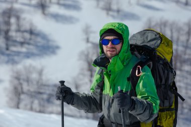 Uzun yürüyüşe çıkan kimse güneşli kış dağlarda