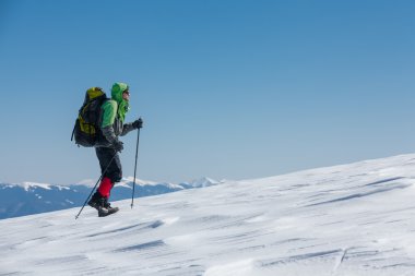 Uzun yürüyüşe çıkan kimse güneşli kış dağlarda