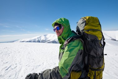 Uzun yürüyüşe çıkan kimse güneşli gün boyunca kış dağlarda