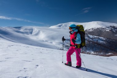 Uzun yürüyüşe çıkan kimse güneşli gün boyunca kış dağlarda