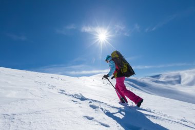 Uzun yürüyüşe çıkan kimse güneşli gün boyunca kış dağlarda