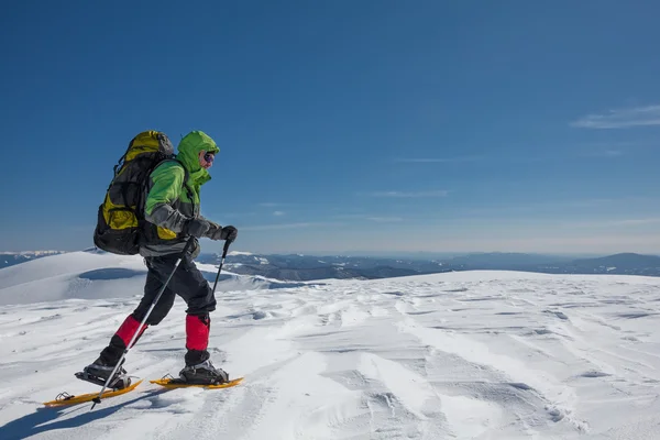 Wandelaar in winter bergen tijdens zonnige dag — Stockfoto