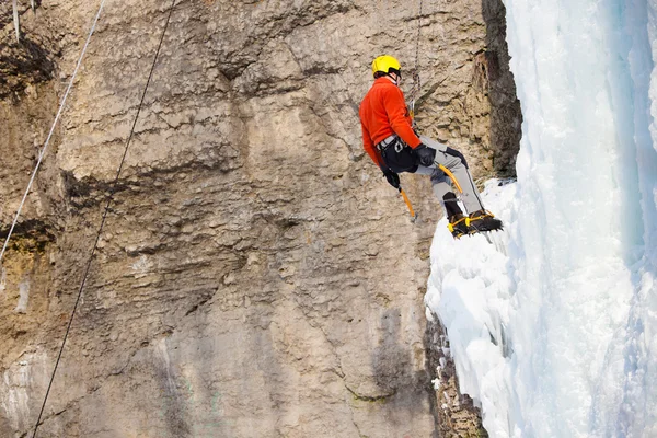 Hombre escalando cascada congelada — Foto de Stock