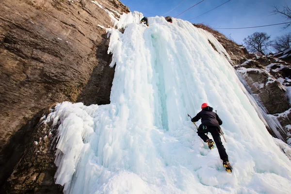 Homem escalando cascata congelada — Fotografia de Stock