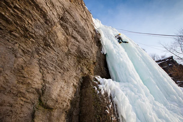 Férfi hegymászó fagyasztott vízesés — Stock Fotó