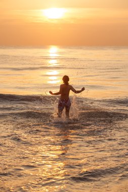 Kadın geri kalan deniz sahilinde alır.