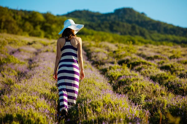 Young woman at lavender field at the sunrise