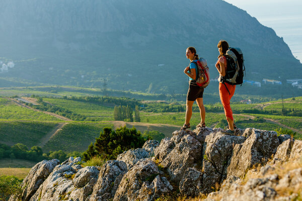 Two women is trekking in the Crimea mountains with backpacks