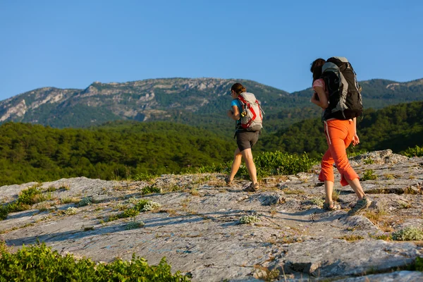 Two women is trekking in the Crimea mountains with backpacks — Stock Photo, Image