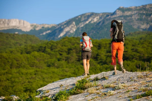 Two women is trekking in the Crimea mountains with backpacks — Stock Photo, Image