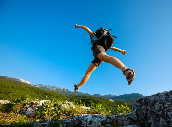 Caminante salta sobre la roca — Foto de Stock