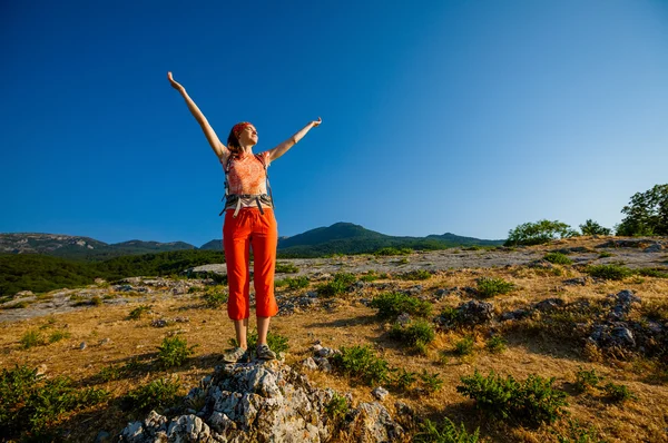 Mujer feliz al amanecer en las montañas — Foto de Stock