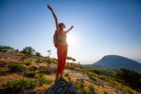 Glückliche Frau beim Sonnenaufgang in den Bergen — Stockfoto