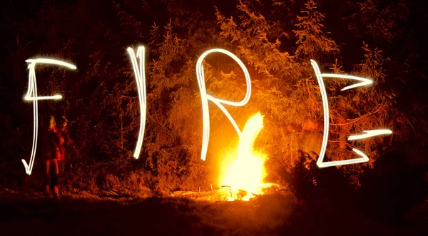 Слова огонь с огнем в ночи — стоковое фото
