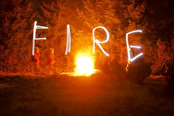 Σχέδιο λέξη φωτιά με φως σε νύχτα — Φωτογραφία Αρχείου
