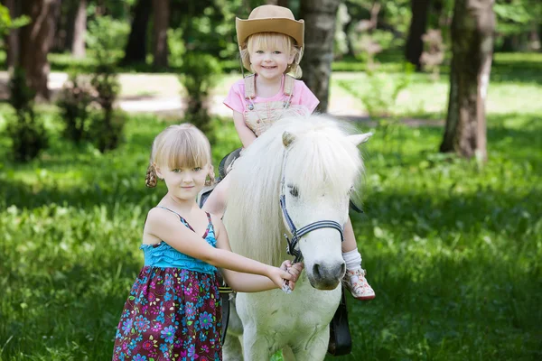 Girls take a walk with pony