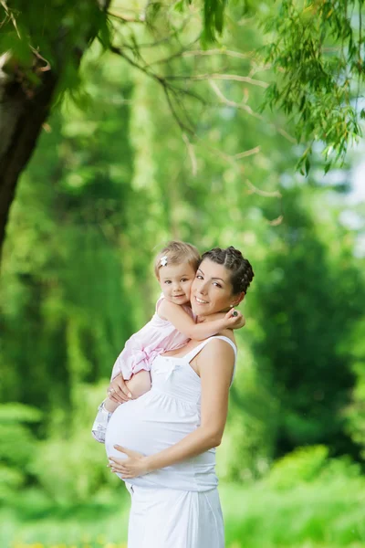 Mãe grávida e sua filha se divertir ao ar livre — Fotografia de Stock