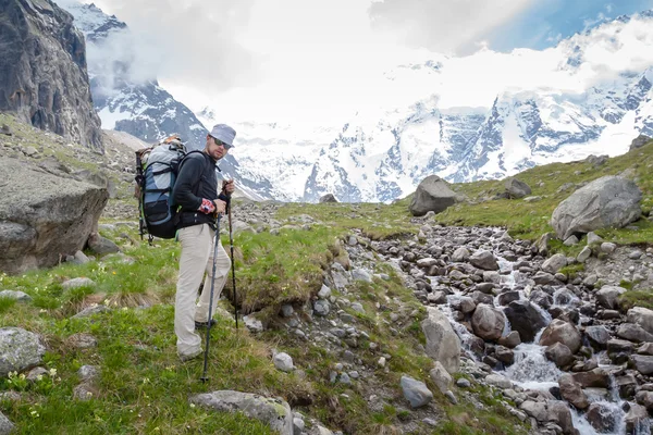 Hikier está escalando la montaña en las montañas del Cáucaso en Bezengi reg — Foto de Stock